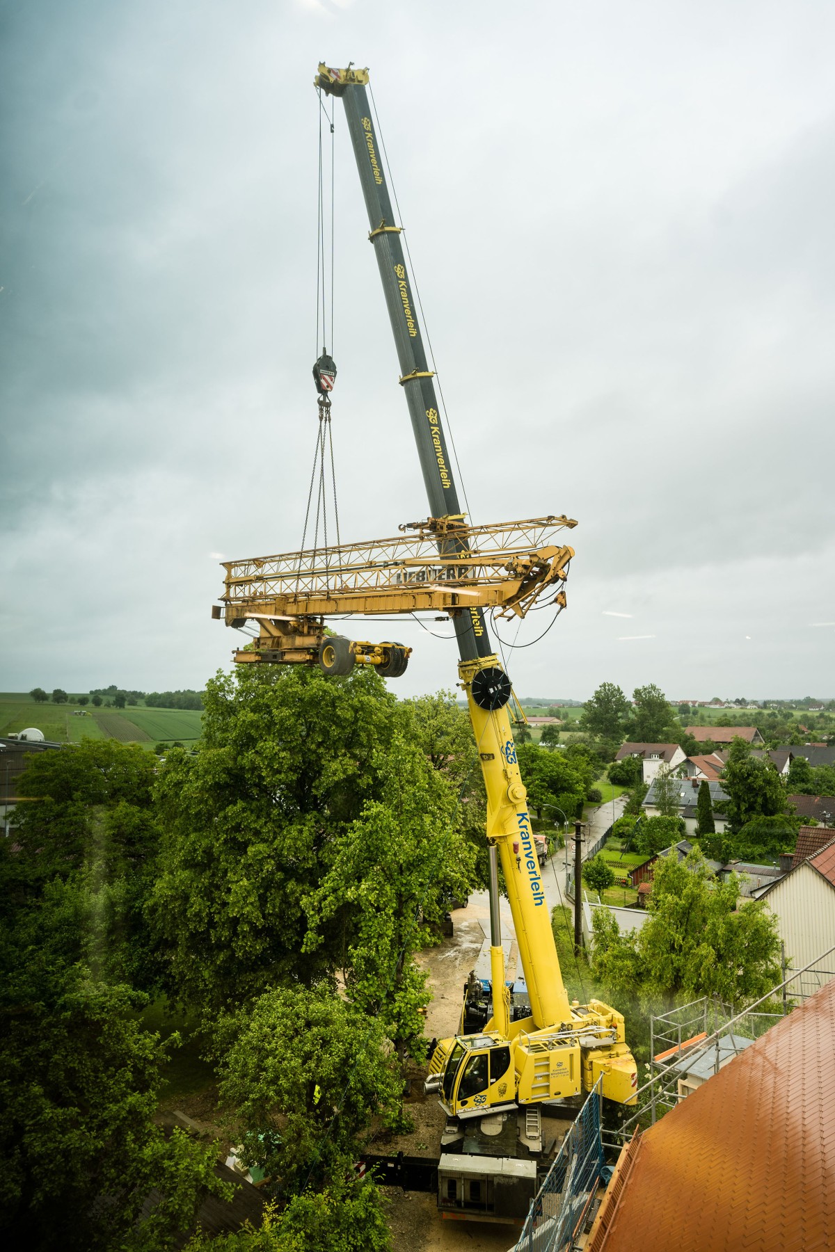 /storage/2024/06/liebherrs-mobile-crane-lifts-construction-crane-over-treetops_66813cf161f8c.jpg