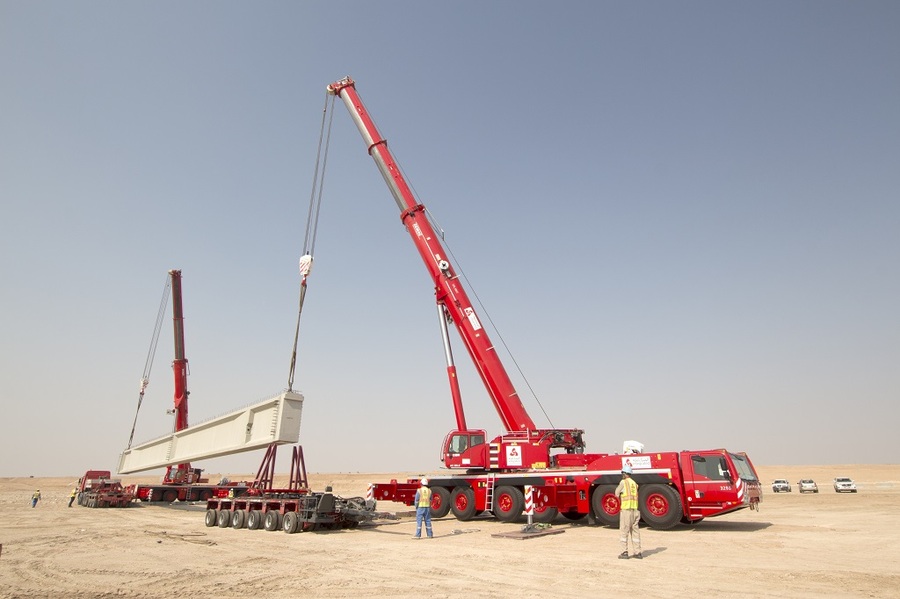 Two Demag AC 300-6 cranes lift concrete supports in the Arabian desert