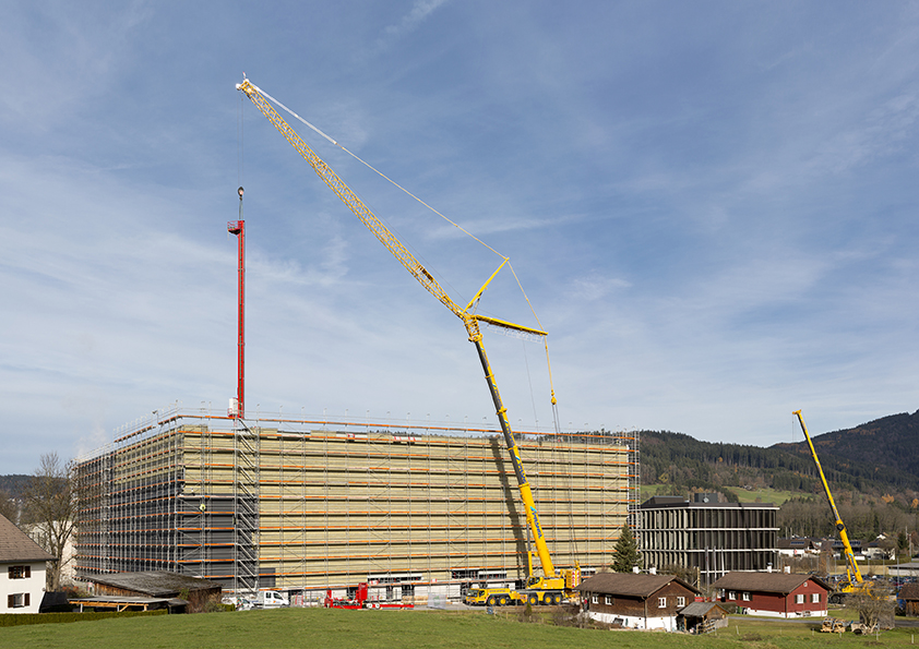 Liebherr LTM 1350-6.1 mobile crane installs storage and retrieval vehicles for high-bay shelving warehouse